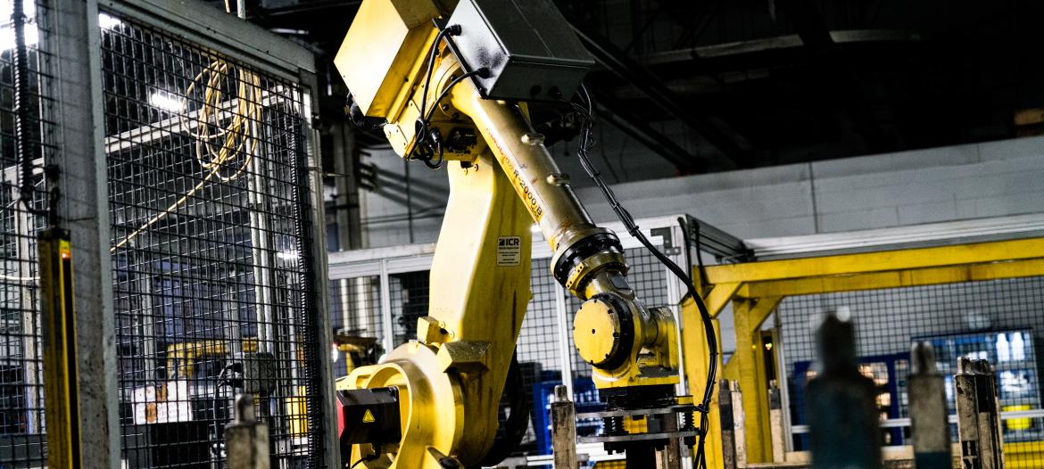 A yellow robotic arm in a factory