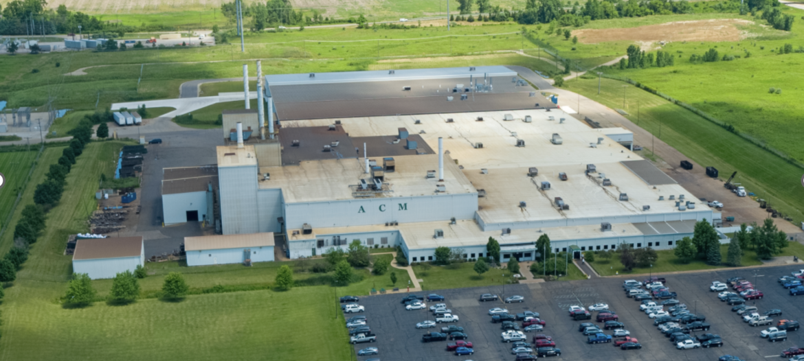 A large building with many cars in the parking lot